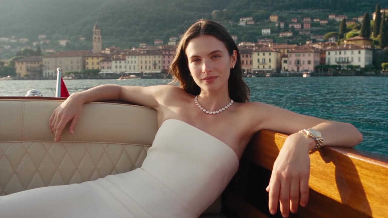 A Seen Studio campaign film frame: a diamond piece on a hand on a terrace at Lake Como at golden hour.